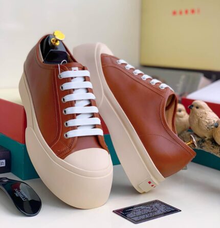 Nigerian-style platform sneakers with white laces and a beige sole, showcasing the brand's signature design. Ideal for everyday wear, these sneakers are a must-have for any Nigerian style enthusiast.
