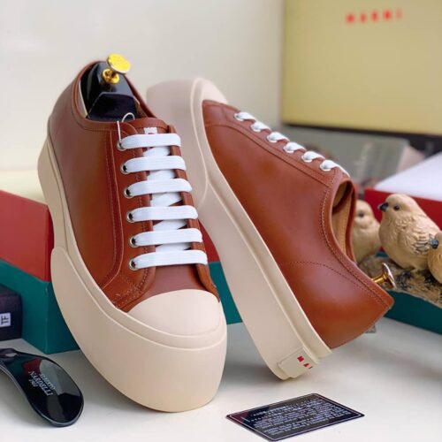 Nigerian-style platform sneakers with white laces and a beige sole, showcasing the brand's signature design. Ideal for everyday wear, these sneakers are a must-have for any Nigerian style enthusiast.