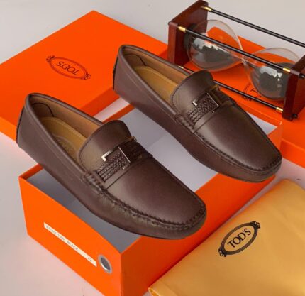Tod's iconic Gommino loafers in rich brown leather, featuring the signature pebble sole for timeless comfort and Italian elegance.